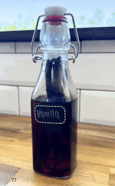 Glass bottle full of brown liquid on kitchen counter with label vanilla extract
