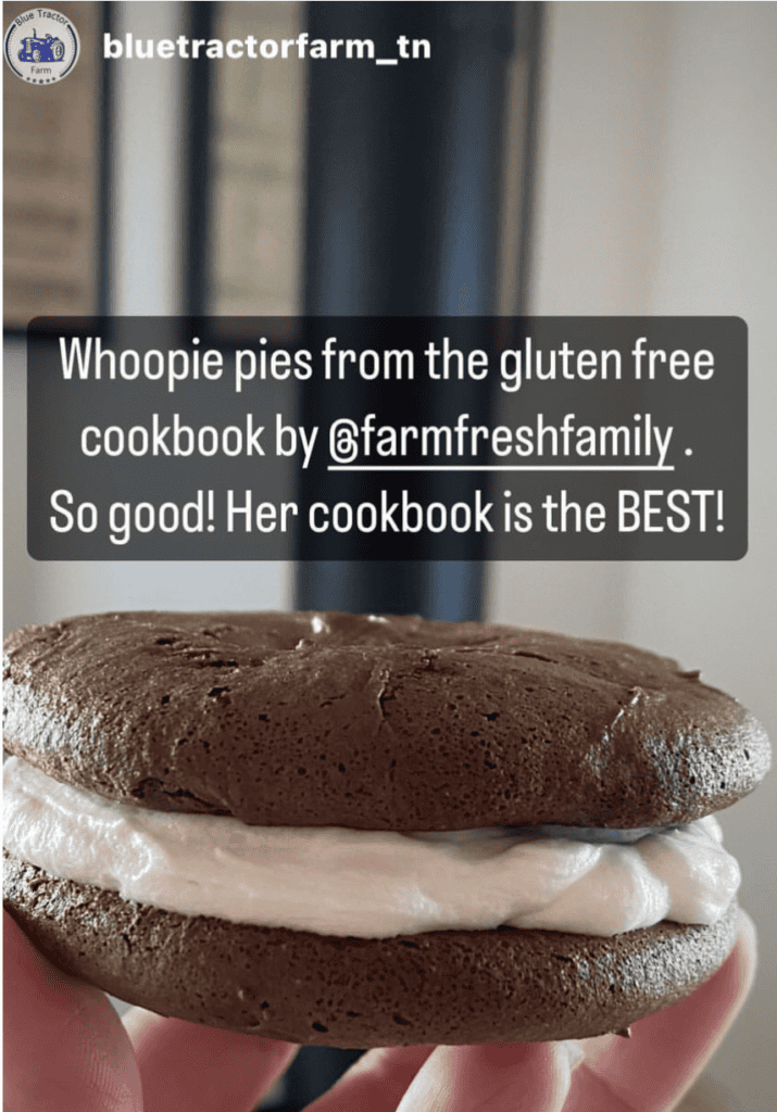 A hand holding a brown sandwich cookie with white creme in the middle and the words Whoopie pies from the gluten free cookbook by @farmfreshfamily. So good! Her cookbook is the BEST!! And at the top the name bluetractorfarm_tn next to a small photo of a blue tractor 