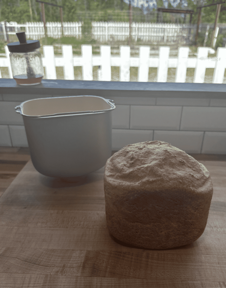 Loaf of bread sitting on counter next to a square pan