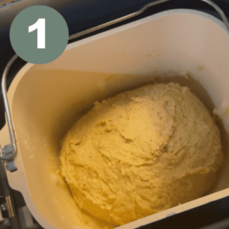 Fresh gluten-free bread dough in bread machine for soft sandwich loaf.