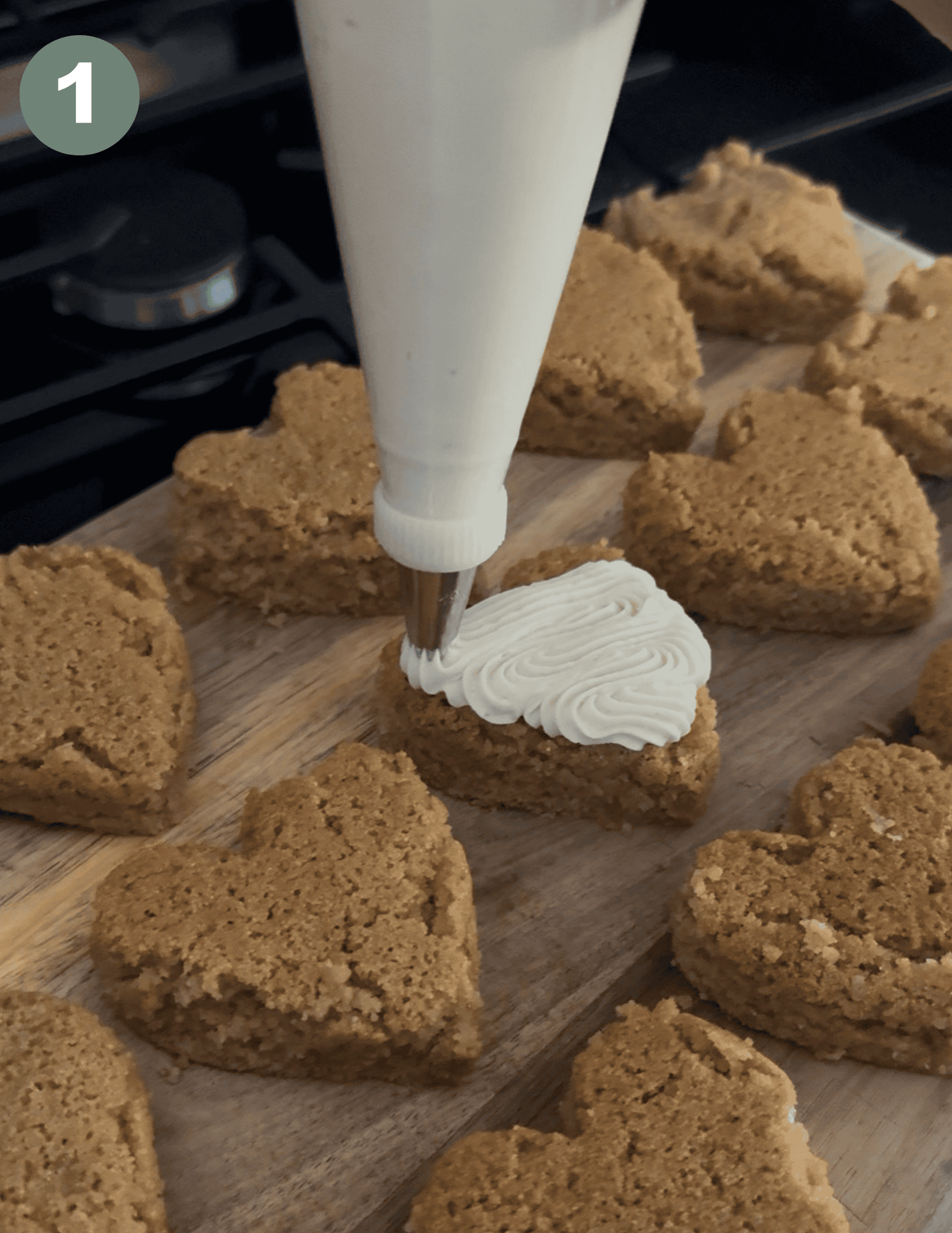 Decorating gluten-free Valentine’s heart cakes with white frosting.