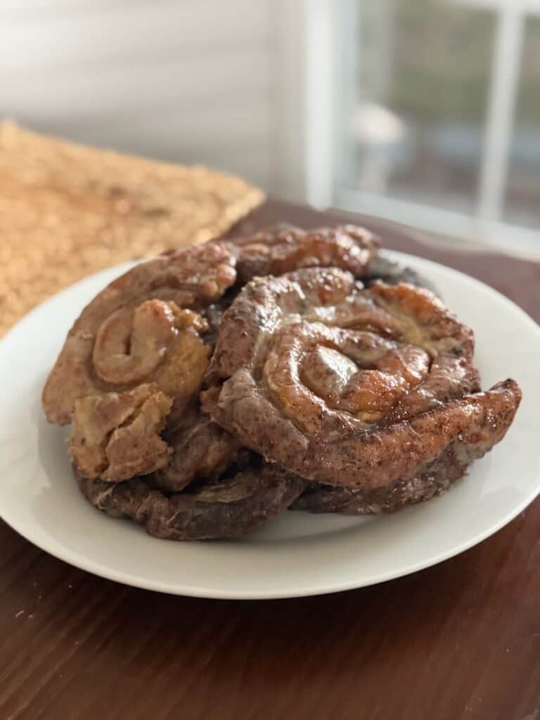 Soft, gluten free honey buns on a white plate.